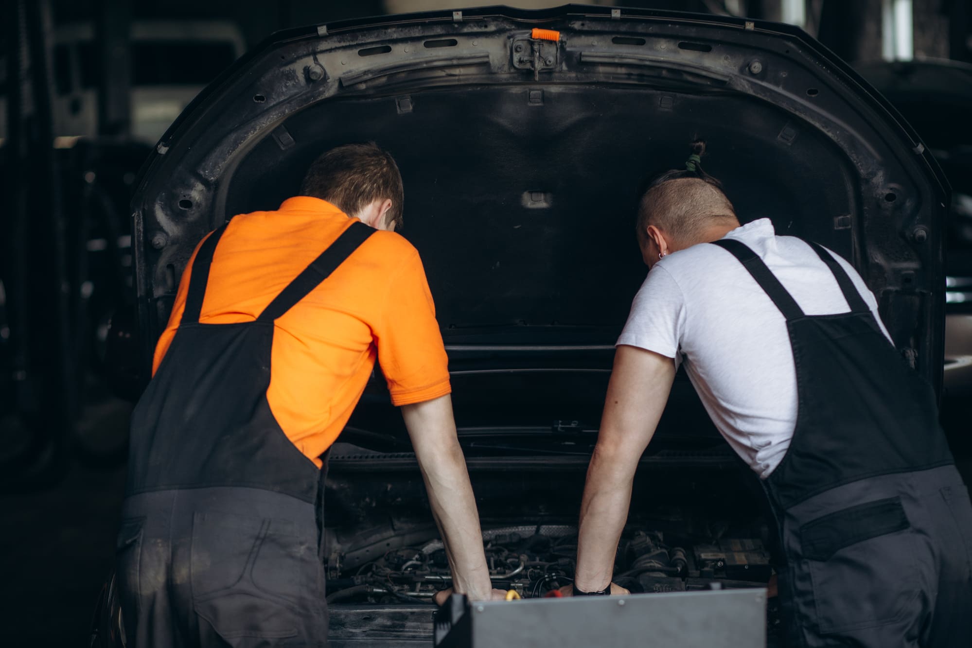 Historia_Automocio_Eduard_Inglada Mecánicos trabajando en un taller mecánico con una larga trayectoria.